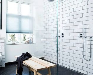 Glass shower wall, white subway wall tile, black fishbone floor tile, bench