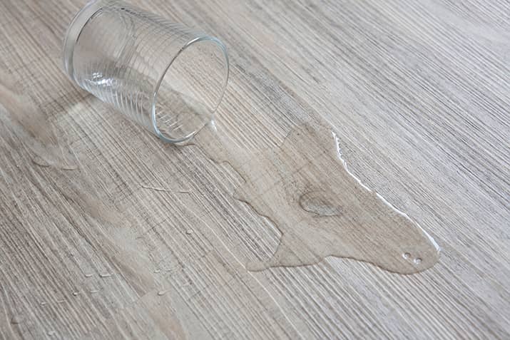 A glass of water spilled on the floor.