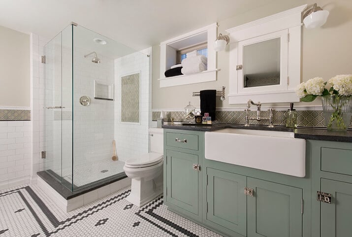 Bathroom with a vessel sink, shaker green cabinets.