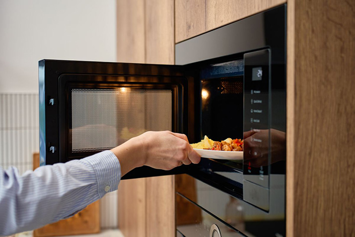 A black microwave mounted above the oven in a convenient stack.