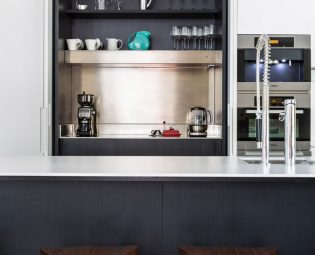 Minimalist and modern coffee station with dark wood and pocket doors.