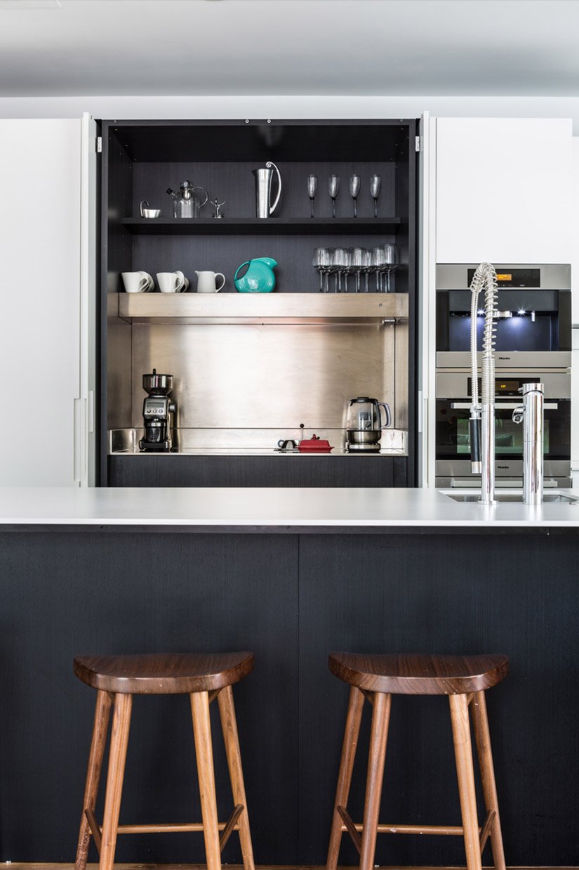 Minimalist and modern coffee station with dark wood and pocket doors.