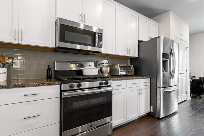 A stainless steel microwave over an oven.