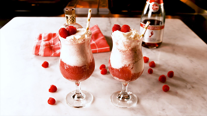 Raspberry Float Mimosa - Raspberry Float Mimosas in glasses topped with whipped cream and raspberries.