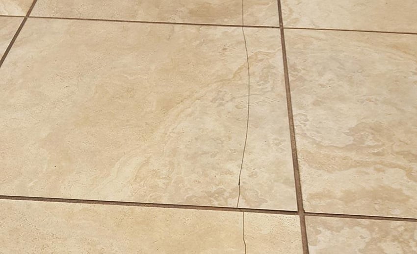 Example before repairing a hairline crack in shower tile.