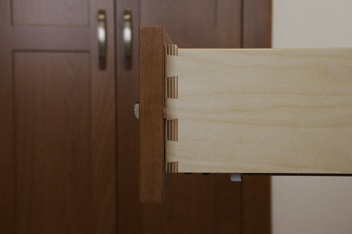 Side view of a wooden drawer with dovetail construction joint.