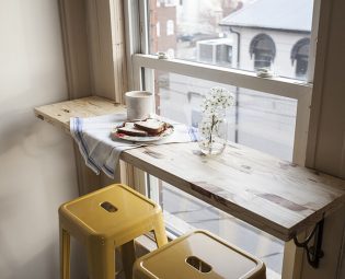 Small DIY breakfast bar across an apartment window.