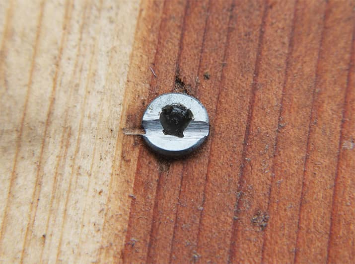 Stripped screw embedded in wood.