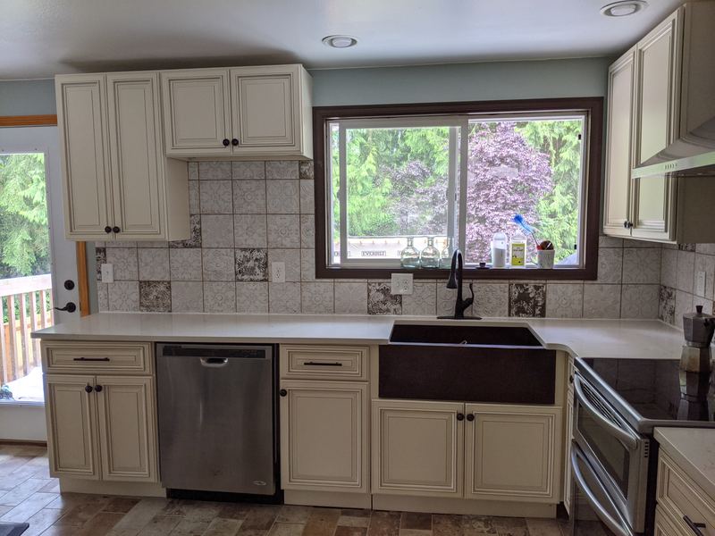 A customer's kitchen with Pearl cabinets and a copper farmhouse sink